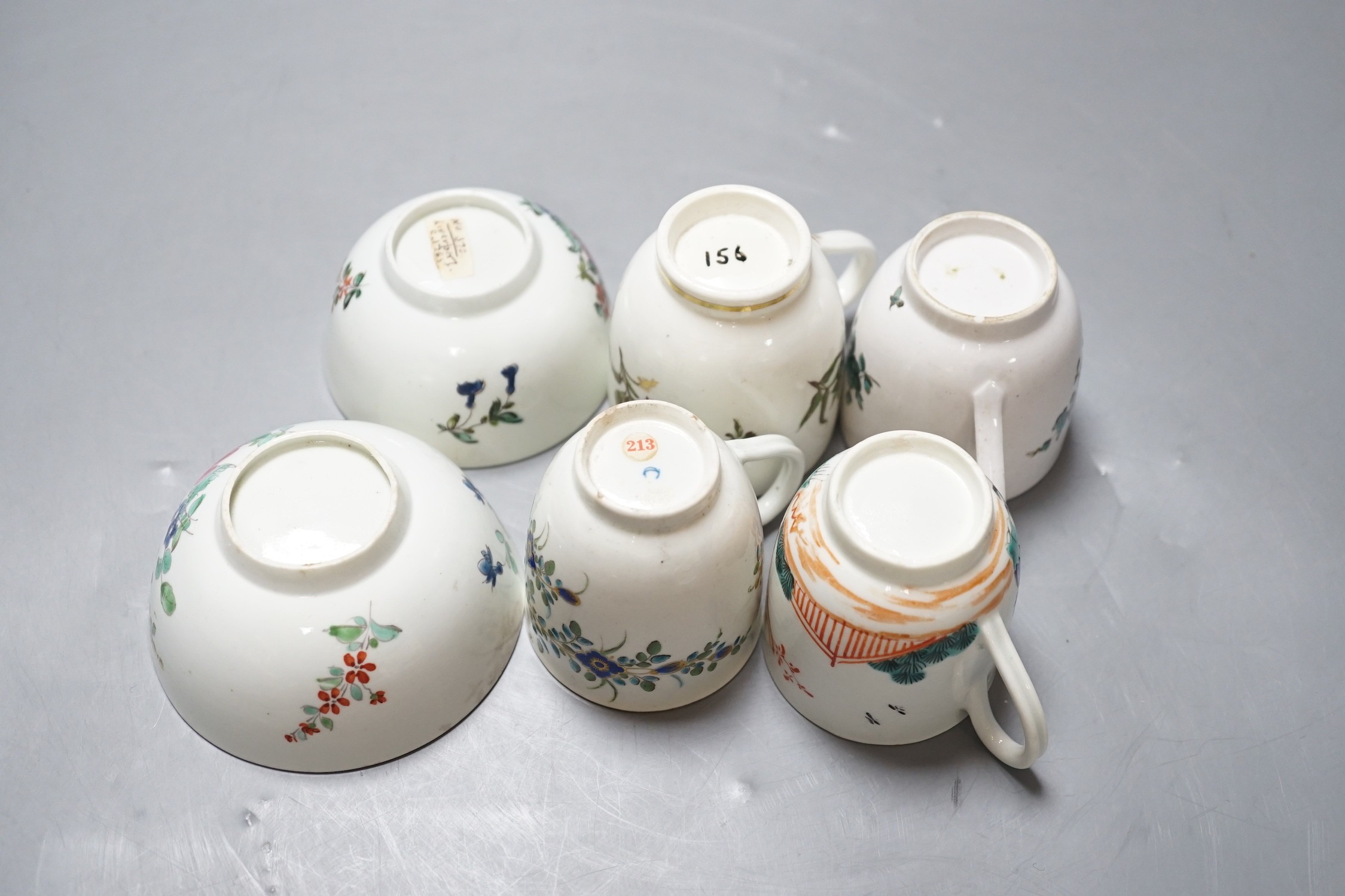 A Worcester coffee cup with oriental figures, another with flowers in green blue and gold, two Chelsea Derby coffee cups and two Christian Liverpool tea bowl with roses, largest bowl 9 cms diameter